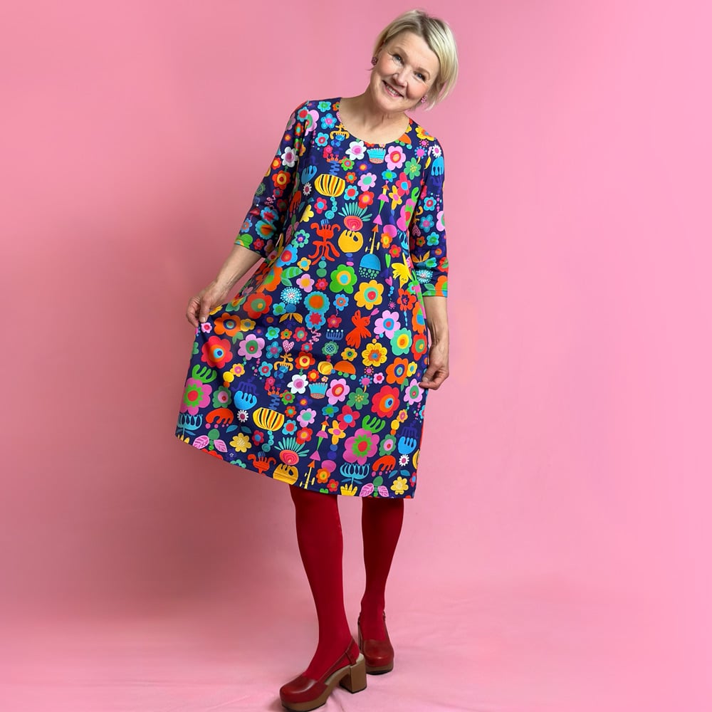 Kotimainen Virkkukoukkusen 3/4-hihainen Kiva-mekko U-pääntiellä. Ommeltu Suomessa todella miellyttävän tuntuisesta, pehmeästä ja ryhdikkäästä trikookankaamme. Aarrejono kuosissa tummansinisellä pohjalla on aarteita pystyjonoissa muodostaen leikkisän kuosin; kukkia, lintuja, sydämiä, palikoita kaikissa sateenkaaren väreissä ja vähän päälle.